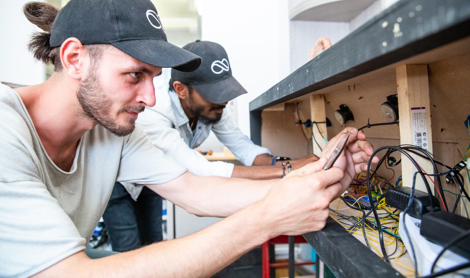 Décorateurs câblant les mécanismes électroniques d'un décor d'Escape Game